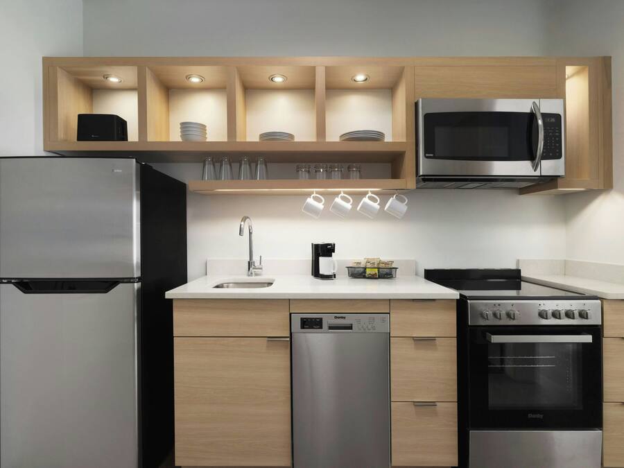 A modern kitchen with a refrigerator, microwave, dishwasher, stove, and cabinets.
