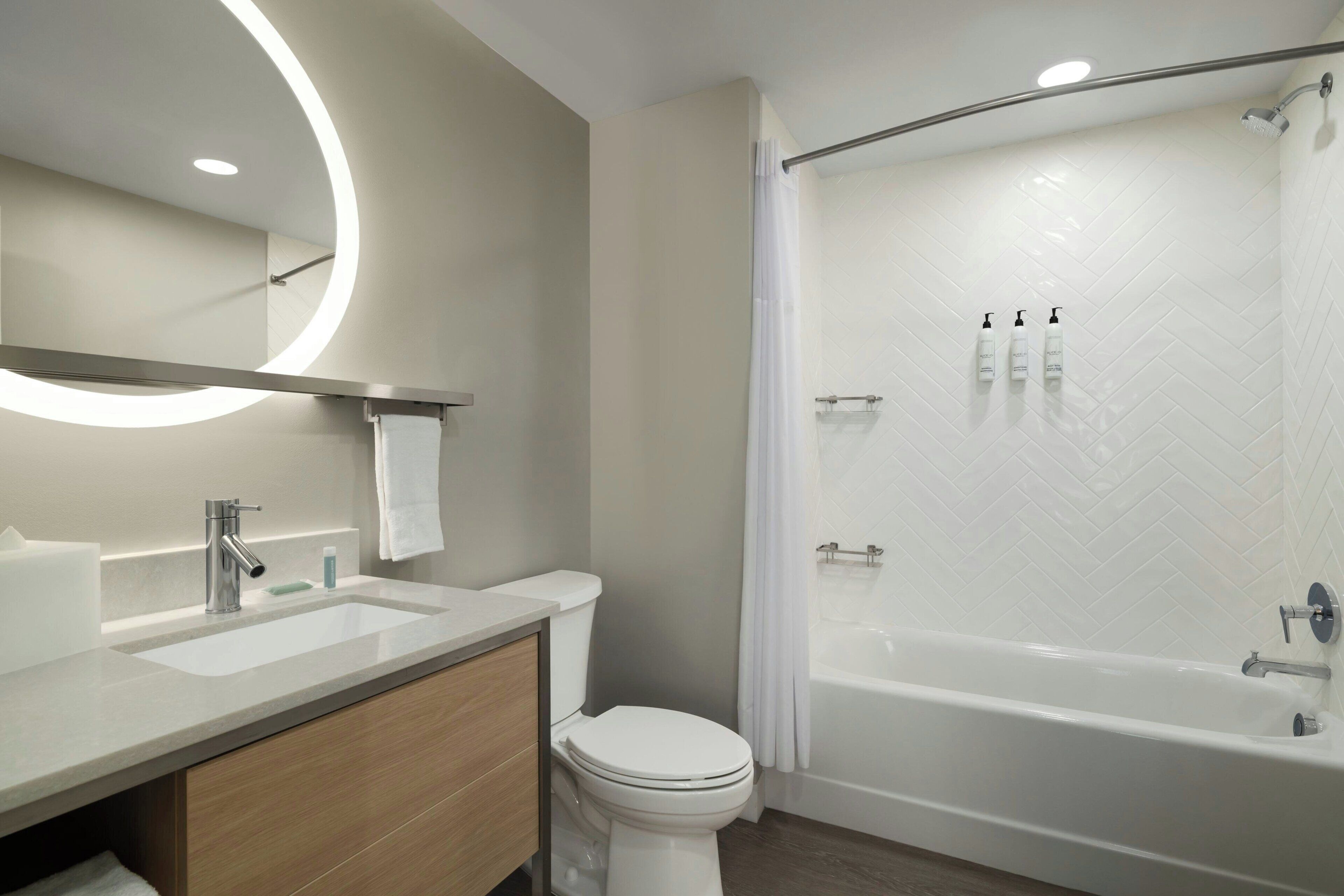 Ein modernes Badezimmer mit Waschtisch, Toilette und begehbarer Dusche.