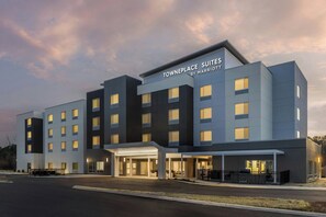 A multi-story hotel with a modern facade, a prominent entrance with a covered area, and a sign indicating it is a Marriott property.