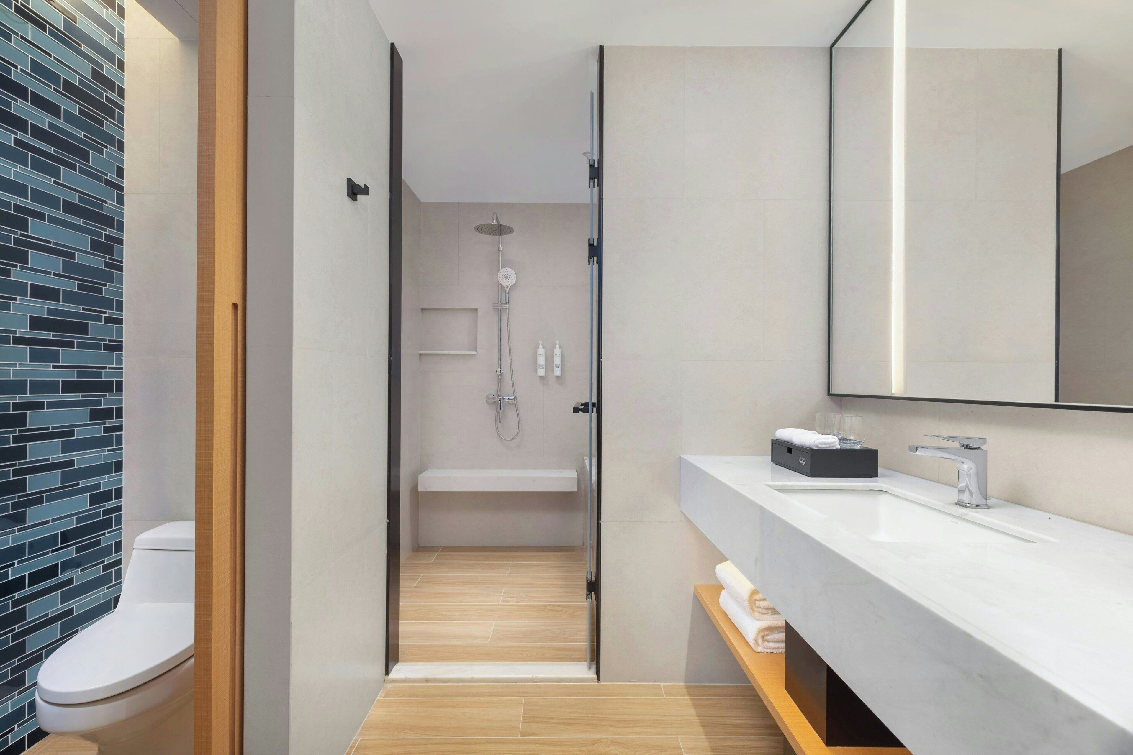 Un baño moderno con ducha, inodoro y tocador.