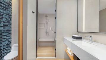 Un baño moderno con ducha, inodoro y tocador.