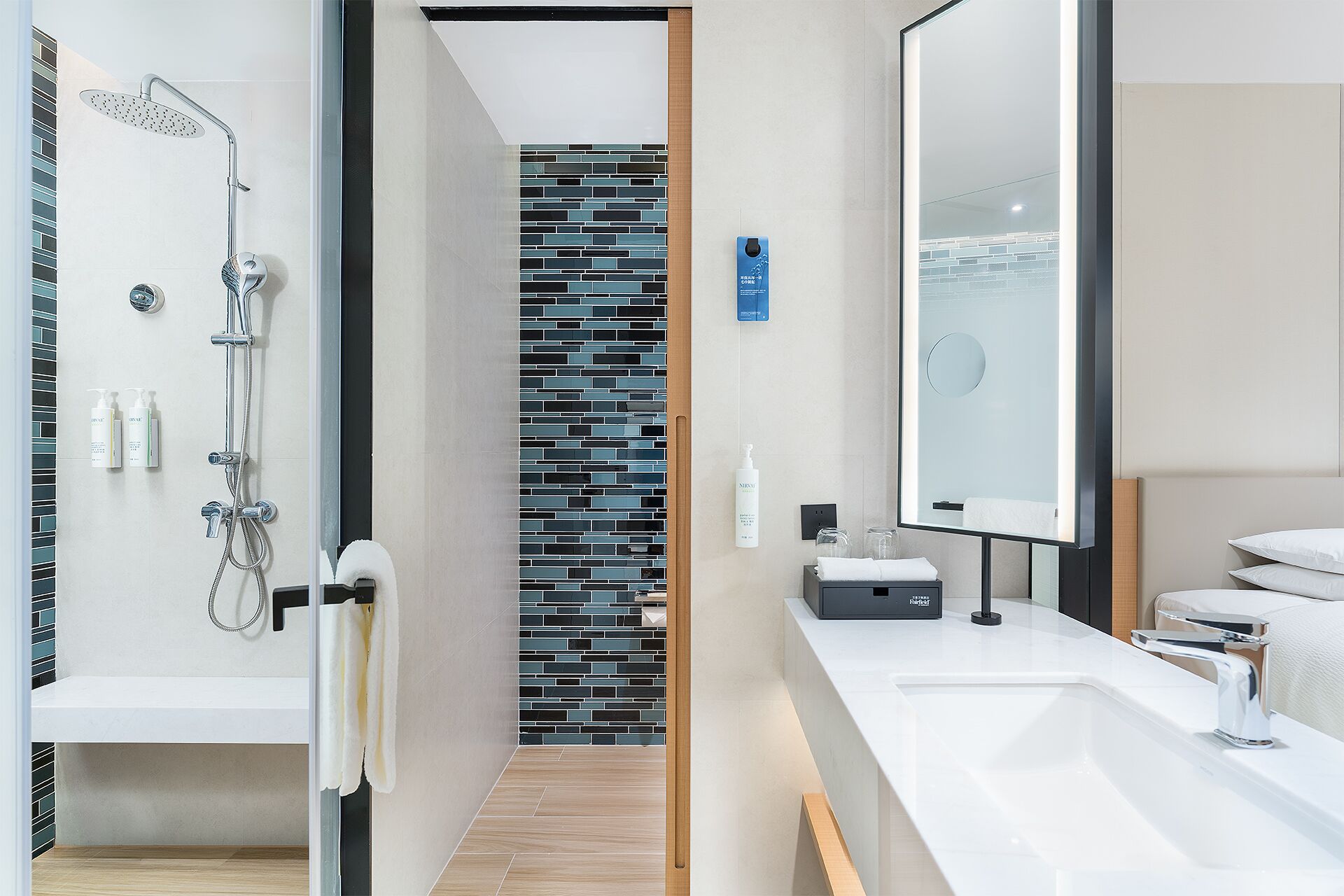 A modern bathroom with a shower, a sink, and a mirror.
