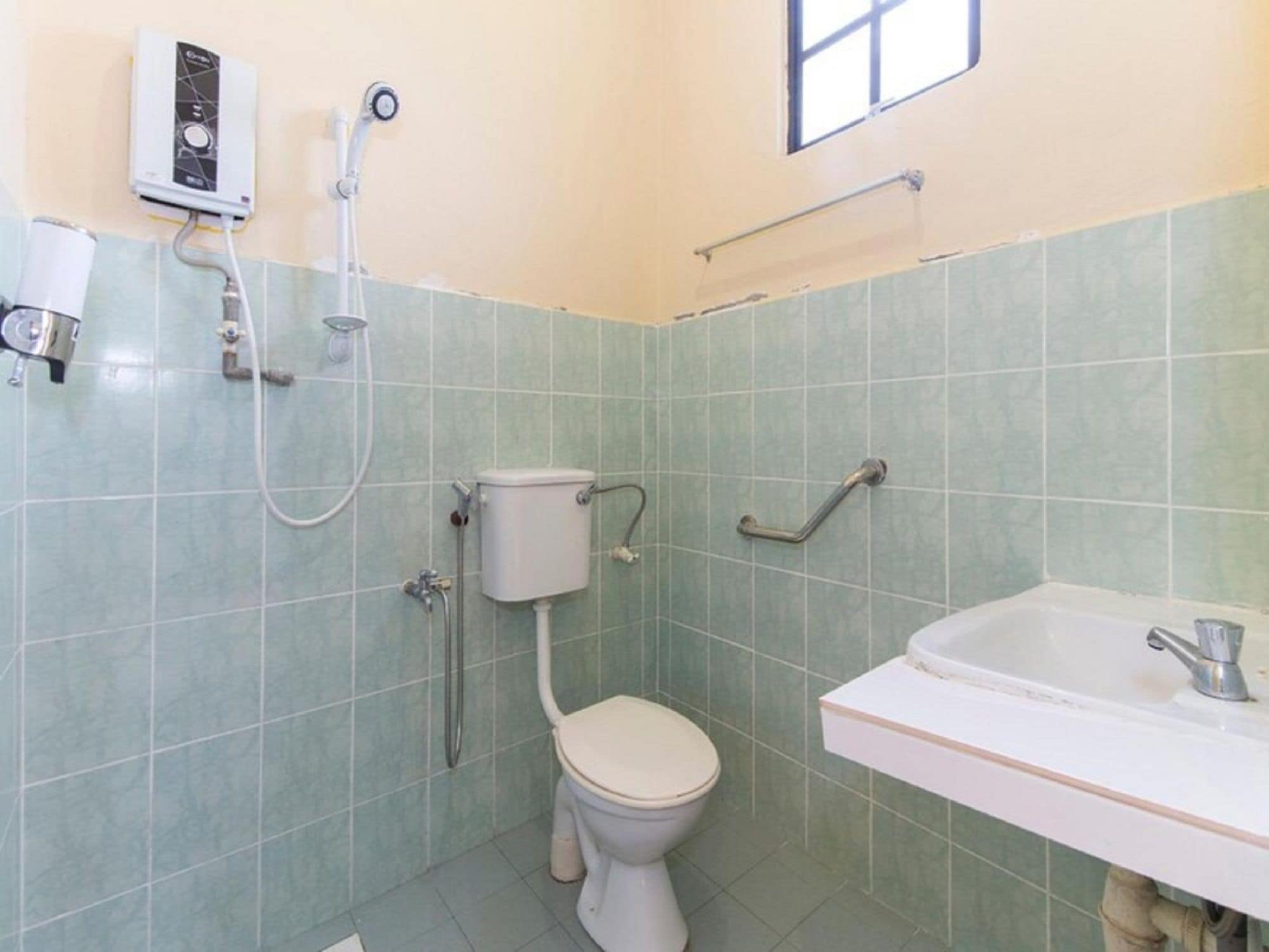 A small bathroom with a toilet, a shower, and a sink.