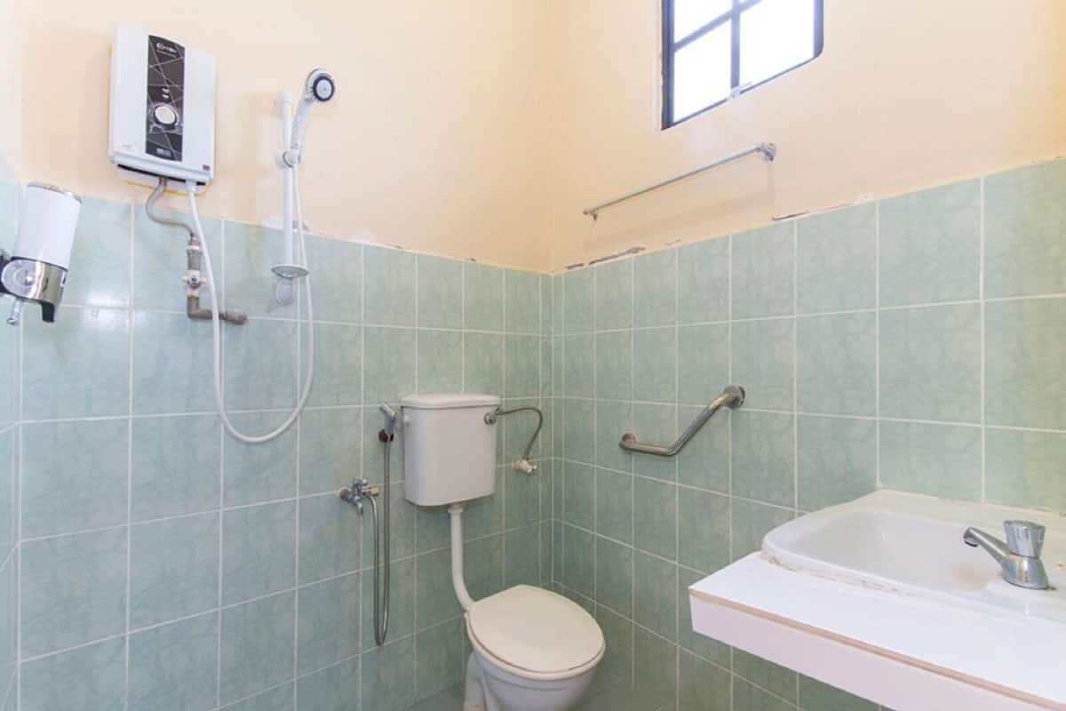 A small bathroom with a toilet, a shower, and a sink.
