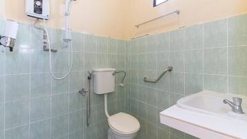 A small bathroom with a toilet, a shower, and a sink.
