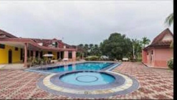 A swimming pool with a circular design, surrounded by a tiled deck. - INB Resort Ayer Keroh Melaka (Malacca City)