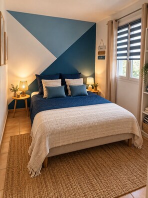 A bedroom with a bed, two bedside tables, a lamp, a wall-mounted sign, and a window with curtains. - Villa Les Chênes Verts – Private Pool – Hot Tub – Provence – Sleeps 10 (Sainte-Anastasie-sur-Issole)
