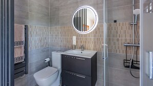 Un baño moderno con inodoro, lavabo y ducha.