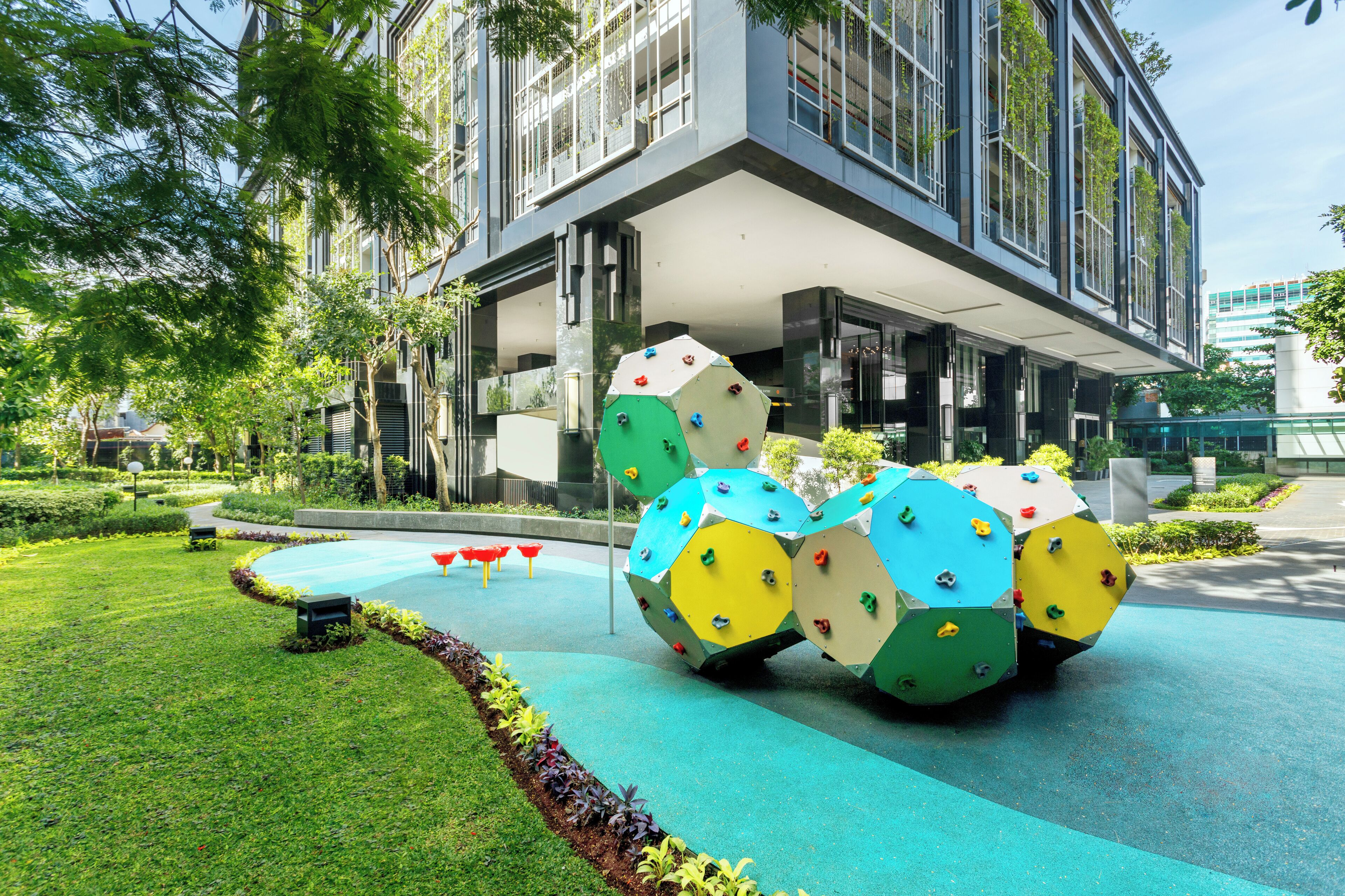 A modern building with a rooftop garden and climbing walls.