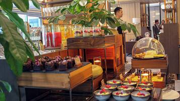 A buffet setup with various food items and a decorative plant.