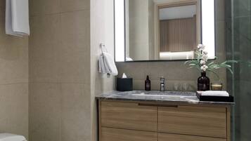 A modern bathroom with a toilet, sink, and mirror.