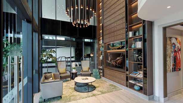 Een moderne woonkamer met een bank, stoelen, een salontafel en een boekenkast.