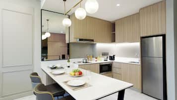 A modern kitchen with a central island, stainless steel appliances, and wooden cabinetry.