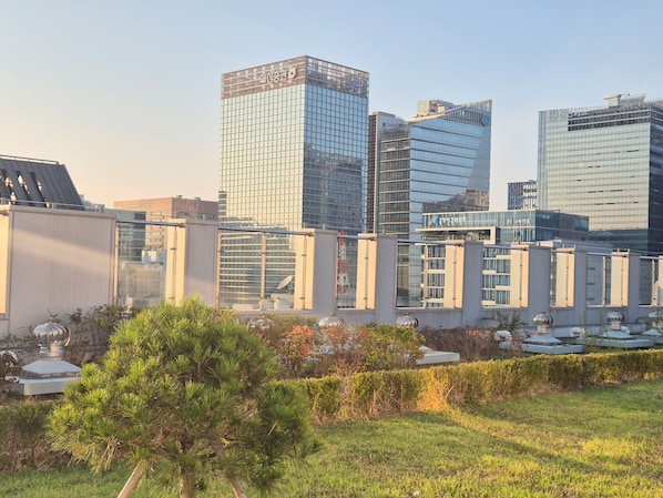 A modern building with glass facades and a flat roof, surrounded by greenery and other buildings. - 27 l Myeongdong 5min l Airport bus l Cozy Room (Seoul)