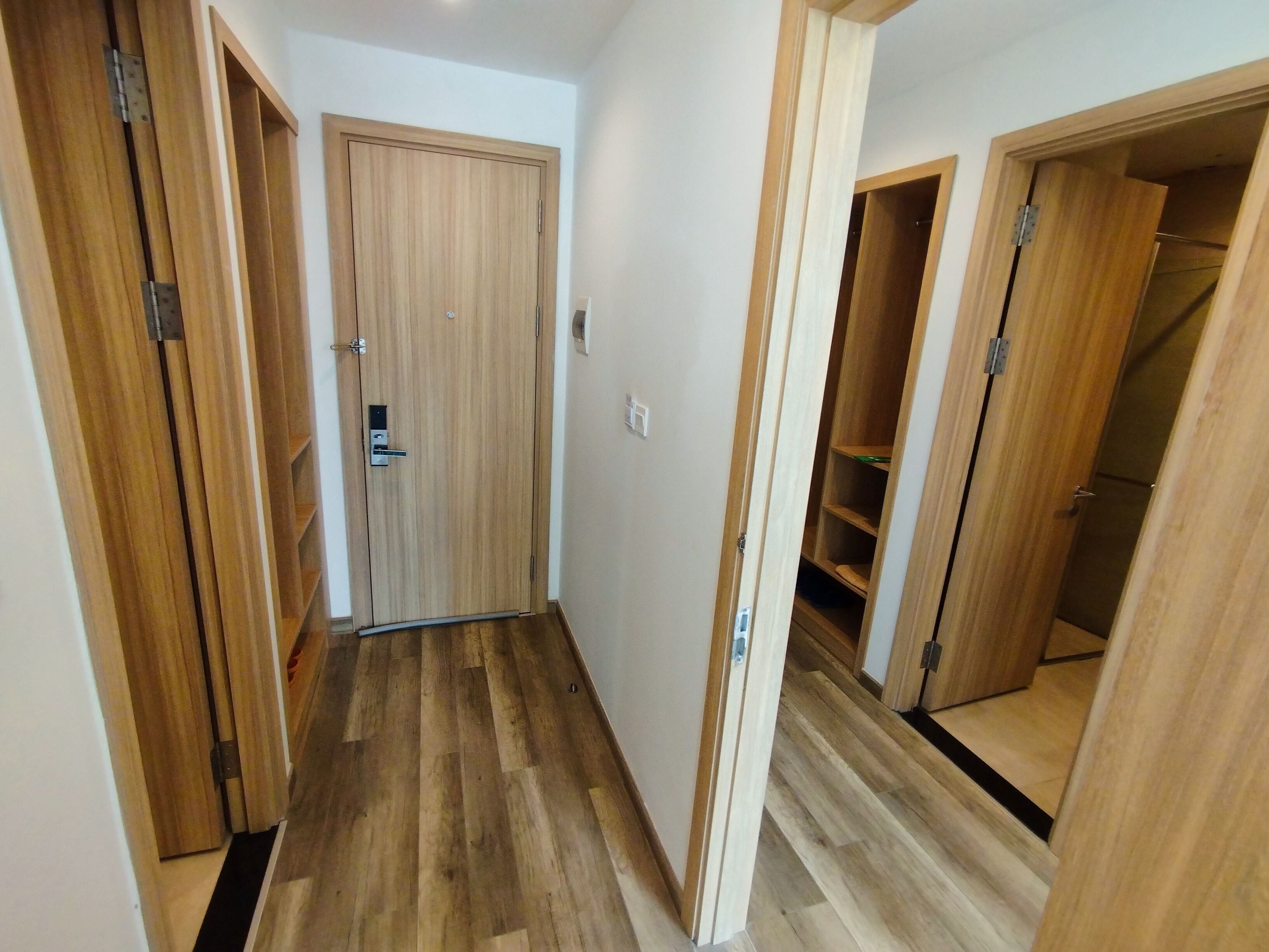 Un couloir étroit, doté d’un plancher en bois et de portes donnant sur des placards.