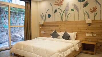 A bedroom with a large bed, wooden headboard, and a mural of flowers on the wall.