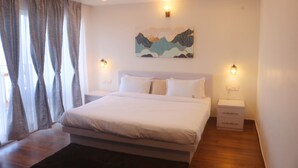 Un dormitorio moderno con una cama grande, mesitas de noche y un cuadro en la pared.
