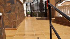 A staircase with beige tiles leading to a gated entrance.