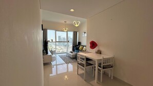 Un salon moderne avec un coin repas, de grandes fenêtres et une vue sur la ville.