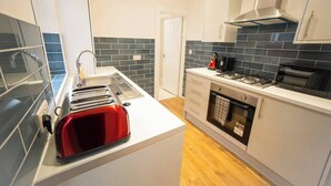 Eine moderne Küche mit Einbauofen, Kochfeld und einem roten Toaster.