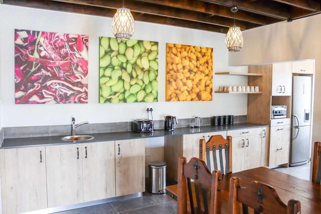 A modern kitchen with a wooden countertop, a sink, and a dining area with a table and chairs.