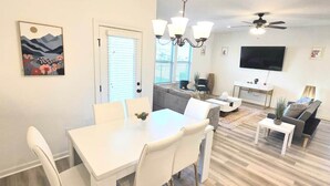 A modern living room with a dining area, a flat-screen TV, and a ceiling fan. - Tigers Geaux Time Getaway in Baton Rouge -  SD5631 (Baton Rouge)