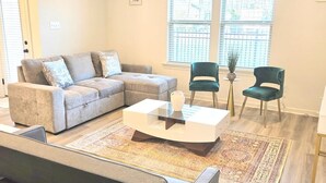 A living room with a sectional sofa, two chairs, a coffee table, and a patterned rug. - Tigers Geaux Time Getaway in Baton Rouge -  SD5631 (Baton Rouge)