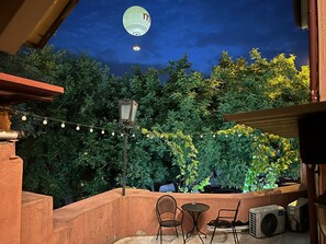 An outdoor patio with a string of lights, a lantern, and a hot air balloon in the background.