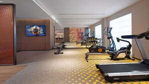 Een moderne sportschool met loopbanden, elliptische trainers en gewichtbanken.