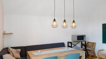 Un espacio moderno para vivir con sofá, mesa de comedor de madera y televisor sobre un mueble bajo.