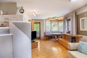 A modern living room with a fireplace, a dining area, and a seating area.