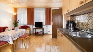 A compact living space with a dining area, kitchenette, and a television. - Apartment '4' with Wi-Fi (Lindau)