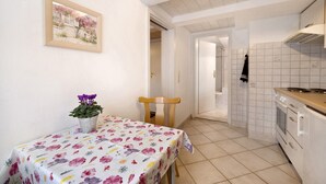 A kitchen with white cabinets, a tiled backsplash, and a wooden countertop. - Apartment '6' with Wi-Fi (Lindau)