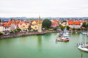 A riverside town with historic buildings, a prominent tower, and a marina with boats. - Apartment '3' with Wi-Fi in Historic Old Town (Lindau)