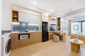 Exclusieve suite, balkon, uitzicht op de binnenplaats | Privékeuken | Een microgolfoven, een kookplaat, kookgerei, borden en bestek