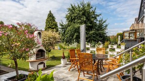 A patio with outdoor furniture, a barbecue grill, and potted plants. - Holiday Apartment 'Waldmann' with Shared Terrace, Garden, and Wi-Fi (Hattorf am Harz)