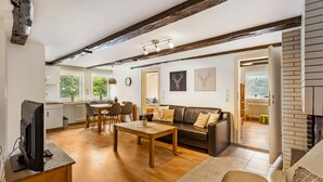 A modern living room with a wooden coffee table, a sofa, and a television on a stand. - Holiday Apartment '3, 53sqm' with Shared Terrace, Shared Garden and Wi-Fi (Schmallenberg)