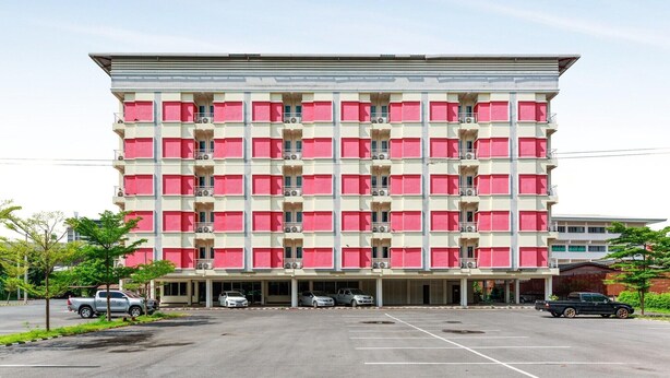 Un hôtel à plusieurs étages, doté d’une façade symétrique, de balcons et d’une entrée centrale.