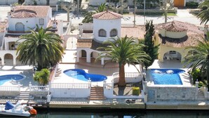 Een resort met meerdere zwembaden, palmbomen en architectuur in mediterrane stijl.