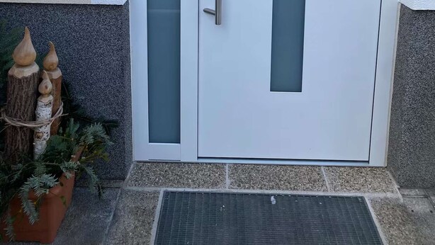 Una puerta blanca con un panel de vidrio esmerilado, un teclado electrónico y un tirador.