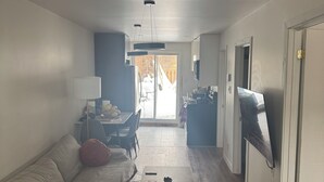 Een moderne woonkamer met een bank, salontafel en televisie.