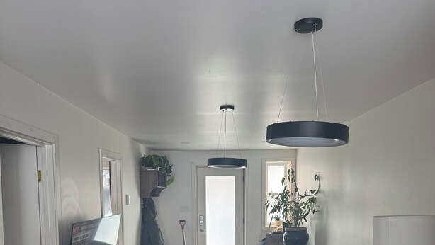 Een moderne woonkamer met een houten vloer, een bank, een salontafel en een eethoek met een marmeren tafel.