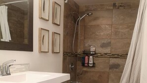 Een moderne badkamer met douche, toilet en wastafel.