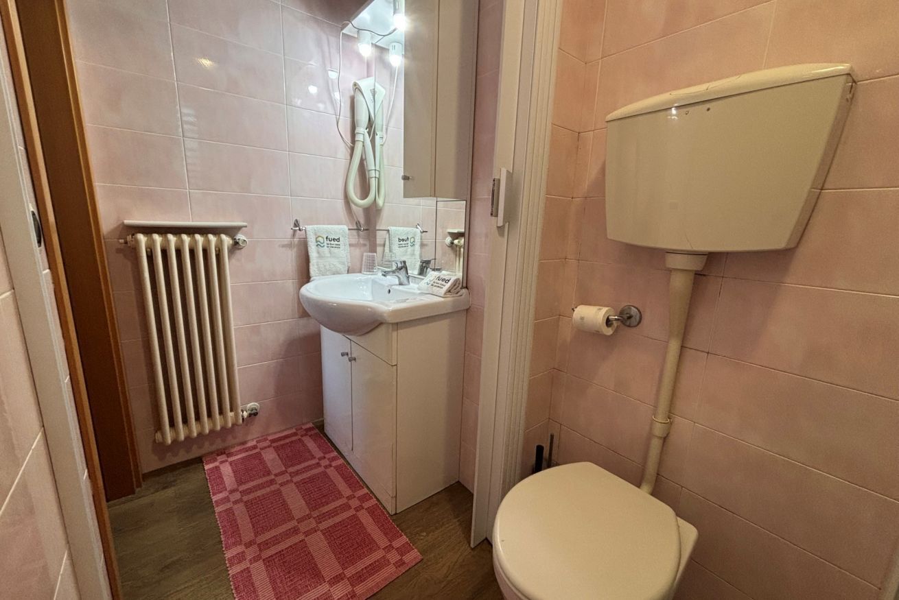 A bathroom with a toilet, sink, and shower.