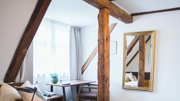 Een hotelkamer met een bed, een bureau en een spiegel.