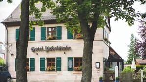 Een gebouw met een bord waarop 'Hotel Birbelstube' staat.
