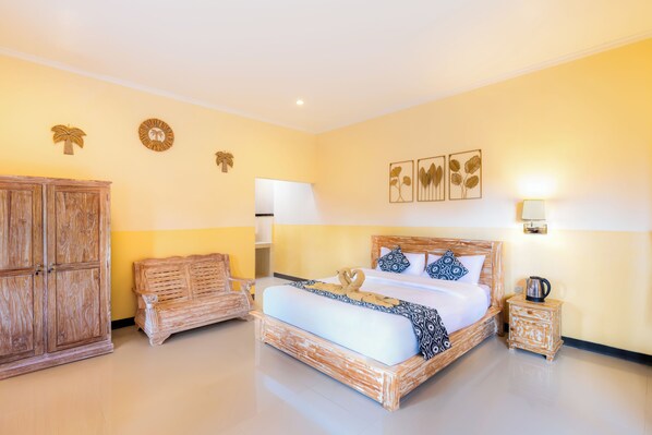 Une chambre d’hôtel avec un lit en bois, une armoire en bois, un banc en bois et une table de chevet avec une lampe.
