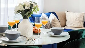A breakfast setting with a table set for two, including bowls, plates, cutlery, and glasses of orange juice. - Charming 1BR in the Heart of Soho and Fitzrovia (London)