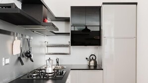 Cocina moderna con estufa a gas, hervidor y utensilios colgantes.