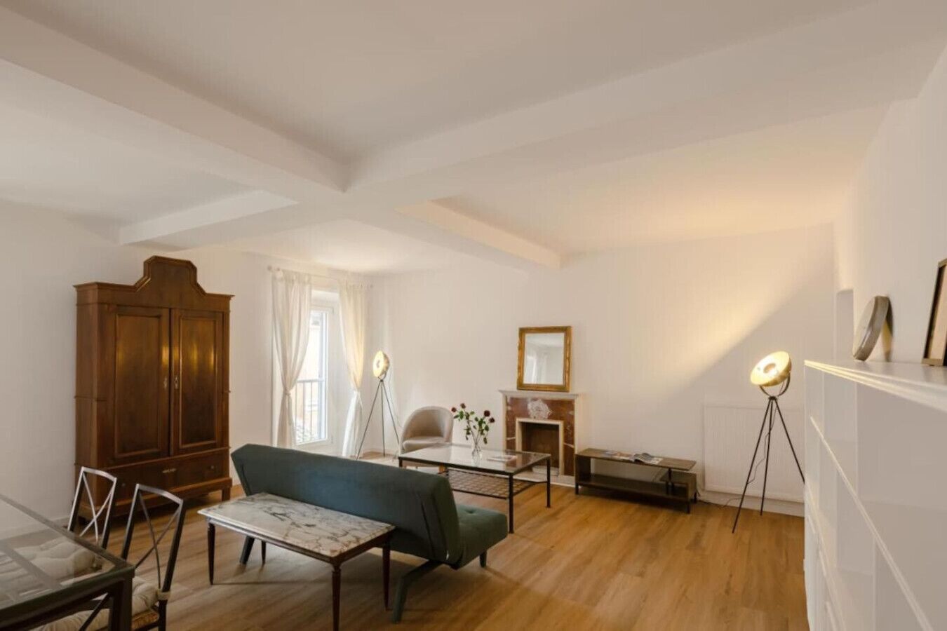 Un salon spacieux avec un meuble en bois, un canapé, une table basse et une cheminée.